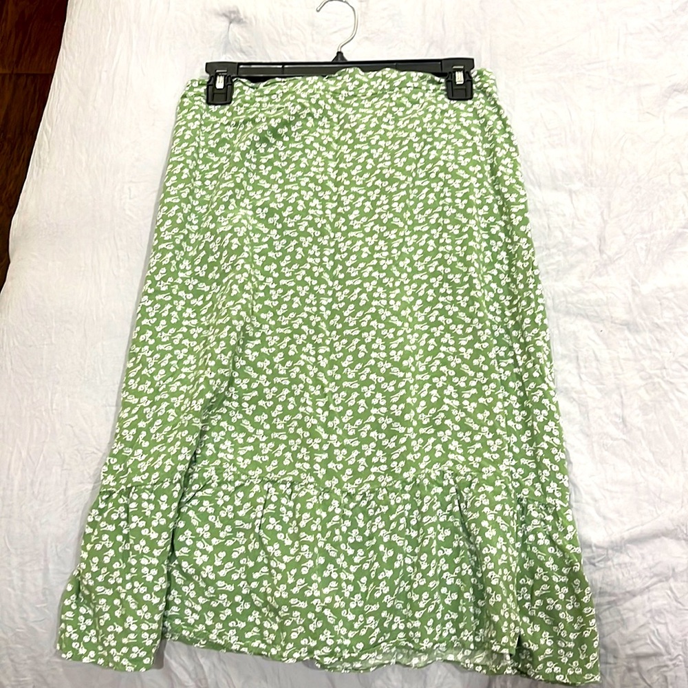 This is a midi skirt that is green with white and black flowers.
